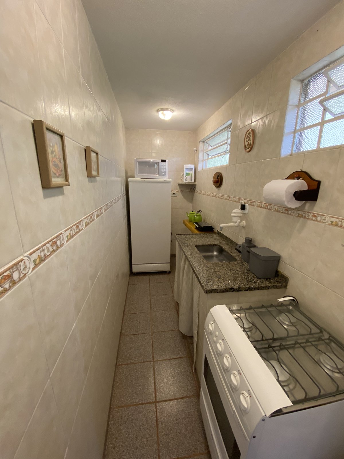 Cozinha completa com fogão, geladeira e microondas
